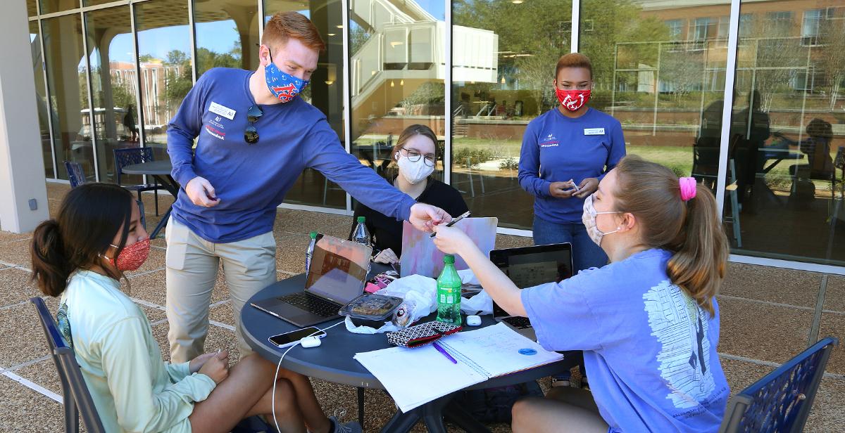 Grant Skinner and Sarai Garraway, both juniors and South Strong Ambassadors at the University of South Alabama, meet with fellow students recently outside the Student Center to talk about the importance of following precautions to keep people safe from COVID-19. 